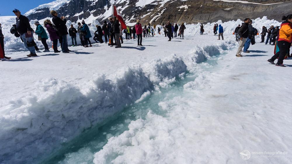 Schmelzwasser auf dem Gletscher und viele Menschen